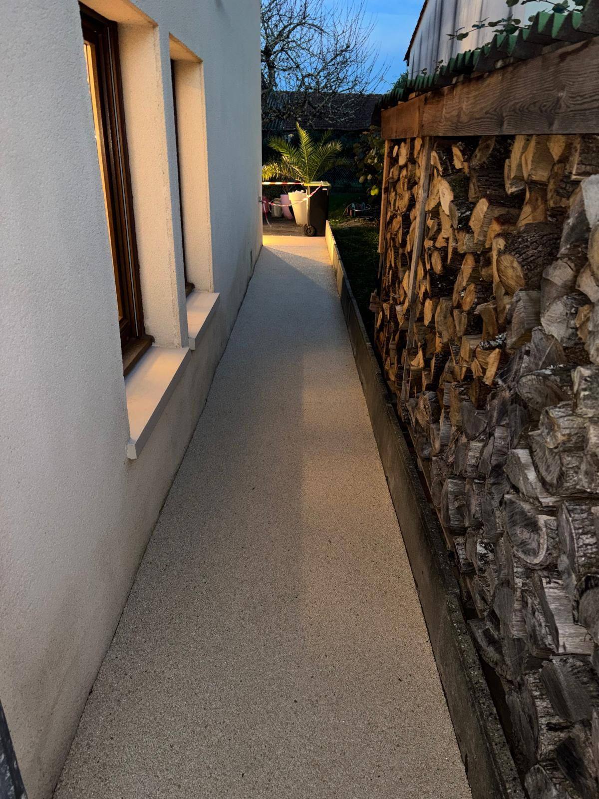 Allée rénovée en marbre et résine vue de nuit après travaux